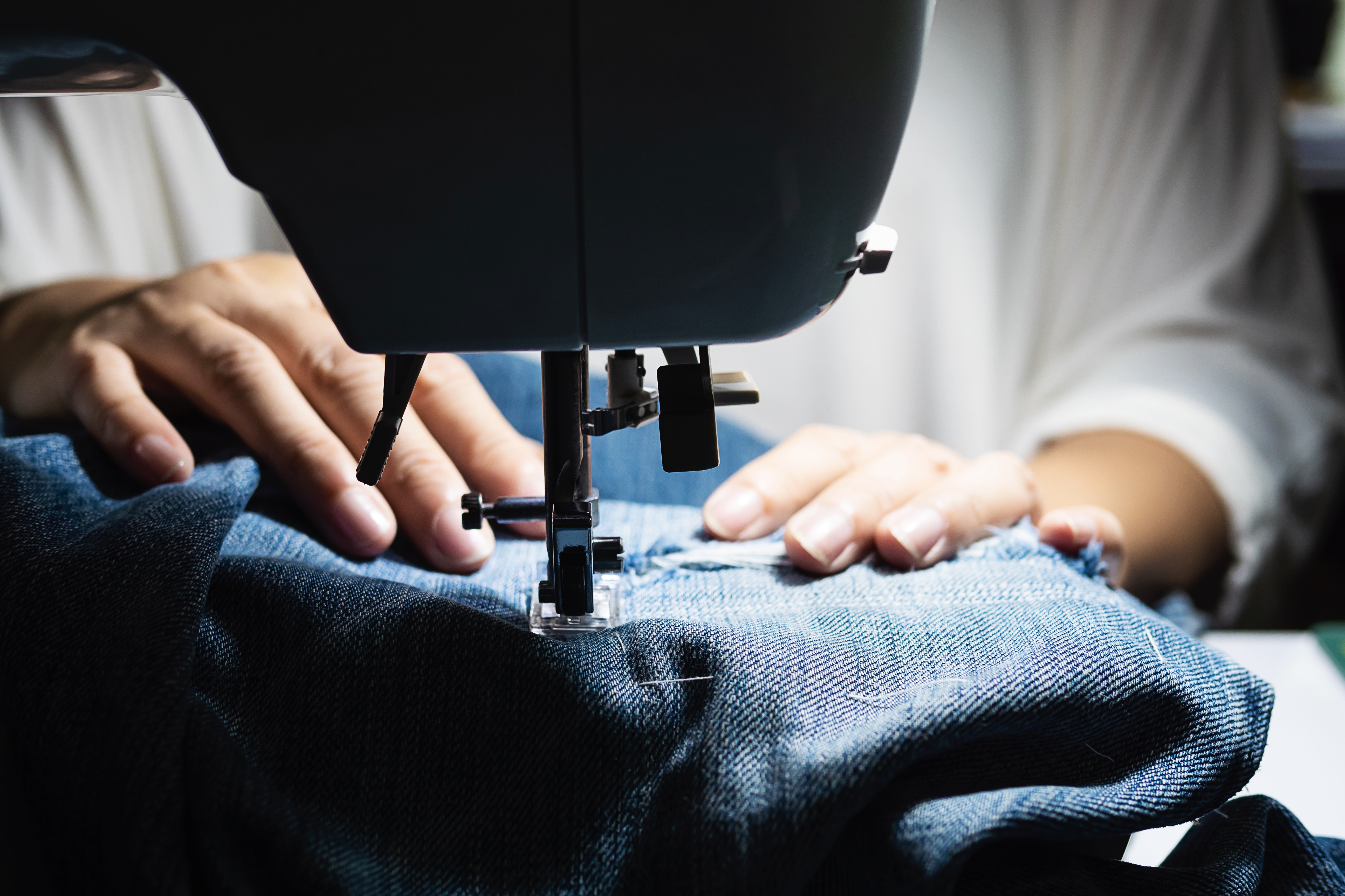woman-doing-jeans-patchwork-using-sewing-machine-home-diy-sewing-concept.jpg